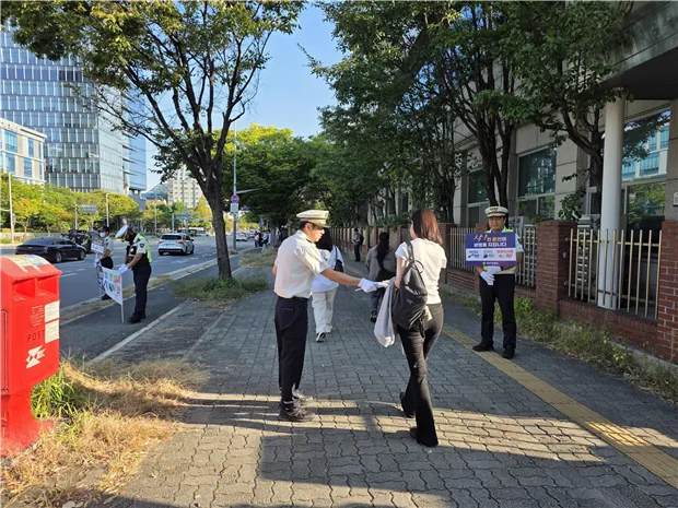 ▲사진설명=대전둔산경찰서 관계자가 정부청사역 인근에서 보행자에게 교통안전 홍보용품을 전달하고 있다.